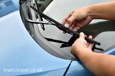 photo of someone fixing windscreen wipers on car